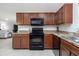 Kitchen with stainless appliances, wood cabinets, granite counters, and tile flooring at 3810 Arboreal Ct, Deland, FL 32724