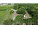Aerial perspective of a rural property with a home, outbuildings, and a serene pond at 396 Uranus Trl, Osteen, FL 32764