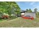 Property featuring a detached garage, storage shed, vehicles, and expansive green space at 396 Uranus Trl, Osteen, FL 32764
