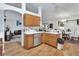 Cozy kitchen featuring wood cabinets, stainless steel dishwasher, laminate floors and open access to living spaces at 396 Uranus Trl, Osteen, FL 32764