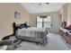 Cozy main bedroom with neutral tones, large window, ceiling fan and furnishings at 396 Uranus Trl, Osteen, FL 32764