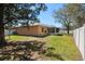 Fenced backyard featuring a large lawn, mature trees and a covered patio at 413 Coventry Estates Blvd, Deltona, FL 32725
