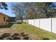 A spacious backyard features a white fence, green grass and mature trees at 413 Coventry Estates Blvd, Deltona, FL 32725