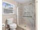 This elegant bathroom showcases a tiled walk-in shower with grab bars and a window for natural light at 413 Coventry Estates Blvd, Deltona, FL 32725