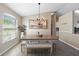 Charming dining area boasting a vaulted ceiling, large windows, modern lighting fixture, and wood-look tile flooring at 413 Coventry Estates Blvd, Deltona, FL 32725
