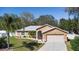 Landscaped single-story home with attached two car garage at 413 Coventry Estates Blvd, Deltona, FL 32725