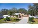 Landscaped single-story home with a paved driveway and white fence at 413 Coventry Estates Blvd, Deltona, FL 32725