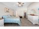 This main bedroom features neutral tones, wood-look tile, a ceiling fan, and ensuite access to the bathroom and closet at 413 Coventry Estates Blvd, Deltona, FL 32725
