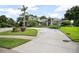 Expansive driveway leading to a well-manicured lawn and a stately home with lush greenery at 420 Greenridge Ct, Debary, FL 32713