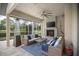 Covered outdoor living area featuring comfortable seating, fireplace, and lush landscaping at 420 Greenridge Ct, Debary, FL 32713