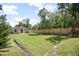 Backyard view showcasing lush lawn, a wooden fence, and an outdoor living space at 429 W Carolina Ave, Deland, FL 32720