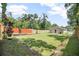 View of the fully-fenced backyard with grass, wood fence, and newly constructed home at 429 W Carolina Ave, Deland, FL 32720
