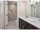 Bathroom with double sinks, dark wood vanity, and glass-door walk-in shower with marble-patterned walls at 429 W Carolina Ave, Deland, FL 32720