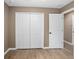 Bedroom with a double door closet, white door and light colored walls and hardwood flooring at 429 W Carolina Ave, Deland, FL 32720
