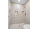 Walk-in shower featuring marble-patterned walls with built-in shelving at 429 W Carolina Ave, Deland, FL 32720