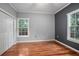 Bedroom featuring wood floors, a ceiling fan, two windows, and closet space at 431 S Stone St, Deland, FL 32720