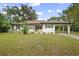 Charming single-story home with white siding, dark shutters, carport, and well-maintained front lawn at 431 S Stone St, Deland, FL 32720