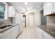 Spacious kitchen with granite counters and stainless appliances leading to laundry area at 431 S Stone St, Deland, FL 32720