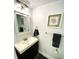 Well-lit bathroom with a stylish vanity, modern fixtures, and decorative seashell artwork at 4786 S Atlantic Ave # 3, Ponce Inlet, FL 32127