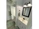 Bright bathroom with double vanity, modern lighting, framed mirror, and gray accents at 4786 S Atlantic Ave # 3, Ponce Inlet, FL 32127