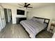 Comfortable bedroom featuring ceiling fan, dresser, television, and light gray wood floors at 4786 S Atlantic Ave # 3, Ponce Inlet, FL 32127