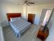 Bedroom featuring ceiling fan, dresser, television, and gray wood floors at 4786 S Atlantic Ave # 3, Ponce Inlet, FL 32127