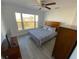 Bedroom featuring ceiling fan, large window, dresser, television, and gray wood floors at 4786 S Atlantic Ave # 3, Ponce Inlet, FL 32127