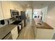 Updated kitchen featuring stainless steel appliances, granite countertops, and views of the dining and living area at 4786 S Atlantic Ave # 3, Ponce Inlet, FL 32127