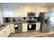 Updated kitchen with stainless steel appliances, granite countertops, and white cabinets at 4786 S Atlantic Ave # 3, Ponce Inlet, FL 32127