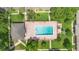 Aerial view of a brick pool area featuring lounge chairs, a pool house, and nearby condos at 511 Polaris Loop # 105, Casselberry, FL 32707