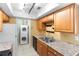Kitchen features wood cabinets, granite countertops, and stacked washer and dryer units at 511 Polaris Loop # 105, Casselberry, FL 32707