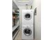 Laundry nook with stacked washer and dryer units and shelving for storage at 511 Polaris Loop # 105, Casselberry, FL 32707