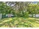 View of the lawn and privacy fence, surrounded by shady trees with Spanish moss at 528 Pine St, Daytona Beach, FL 32114