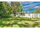 Private backyard with a well-maintained lawn, partial shade, and a white vinyl fence for added seclusion at 528 Pine St, Daytona Beach, FL 32114