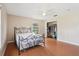 This bedroom features wood floors, a ceiling fan, and an open closet with clothes, storage bins and shelving at 5759 Dogwood Rd, Port Orange, FL 32127