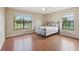 This bedroom features wood floors, neutral paint, a ceiling fan, and bright windows with scenic views at 5759 Dogwood Rd, Port Orange, FL 32127