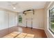 This bedroom features wood floors, a ceiling fan, and a surfboard mounted on the wall with storage at 5759 Dogwood Rd, Port Orange, FL 32127
