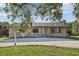 Charming stone facade home with a well-manicured lawn and mature trees creating curb appeal at 5759 Dogwood Rd, Port Orange, FL 32127