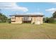 Back of house view highlighting the deck, lower level access, and spacious yard at 5759 Dogwood Rd, Port Orange, FL 32127