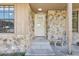 Close up of front stone facade entrance with a white door and small bench by the entrance at 5759 Dogwood Rd, Port Orange, FL 32127