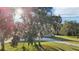 Charming front yard view with mature trees and lush landscaping, leading to a stone facade home at 5759 Dogwood Rd, Port Orange, FL 32127
