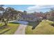 Stunning front yard with mature trees, a long circular driveway and a stone facade home at 5759 Dogwood Rd, Port Orange, FL 32127