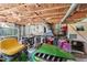 View of garage with exposed ceiling insulation, storage, and a green riding lawn mower at 5759 Dogwood Rd, Port Orange, FL 32127