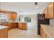 Kitchen with wooden cabinets and stainless steel refrigerator overlooking a large eating area with bay window at 5759 Dogwood Rd, Port Orange, FL 32127