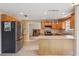 Kitchen with stainless steel appliances, wood cabinets, tile floors, and view into the living room at 5759 Dogwood Rd, Port Orange, FL 32127