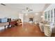 Spacious living room with hardwood floors, fireplace, ceiling fan and a large bay window at 5759 Dogwood Rd, Port Orange, FL 32127