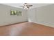 A simple bedroom features hardwood floors, a ceiling fan, and a window view at 600 N Boundary Ave # 420, Deland, FL 32720