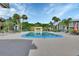 A large community pool surrounded by lounge chairs and palm trees at 600 N Boundary Ave # 420, Deland, FL 32720