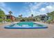 A large community pool surrounded by lounge chairs and palm trees at 600 N Boundary Ave # 420, Deland, FL 32720