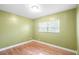 This bedroom features bright green walls, bright windows, and updated laminate floors at 611 N Garfield Ave, Deland, FL 32724